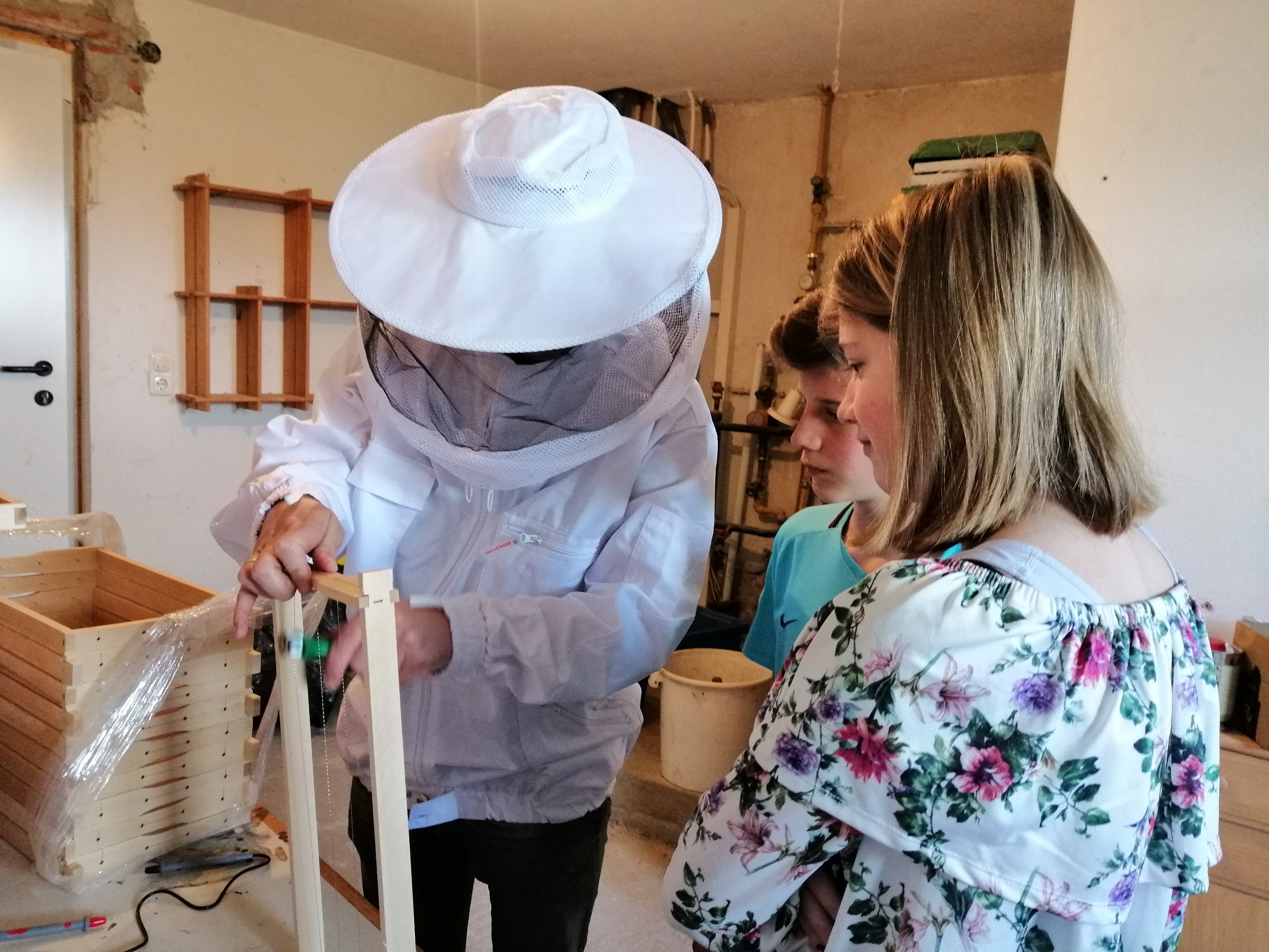 David Huber mit Kindern bei der Bienenarbeit